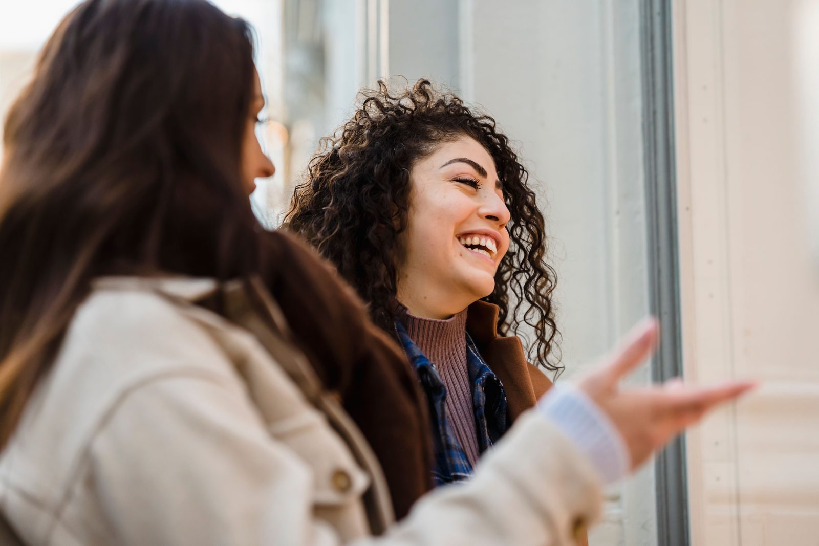 Two friends laughing together, enjoying connection without constant worry