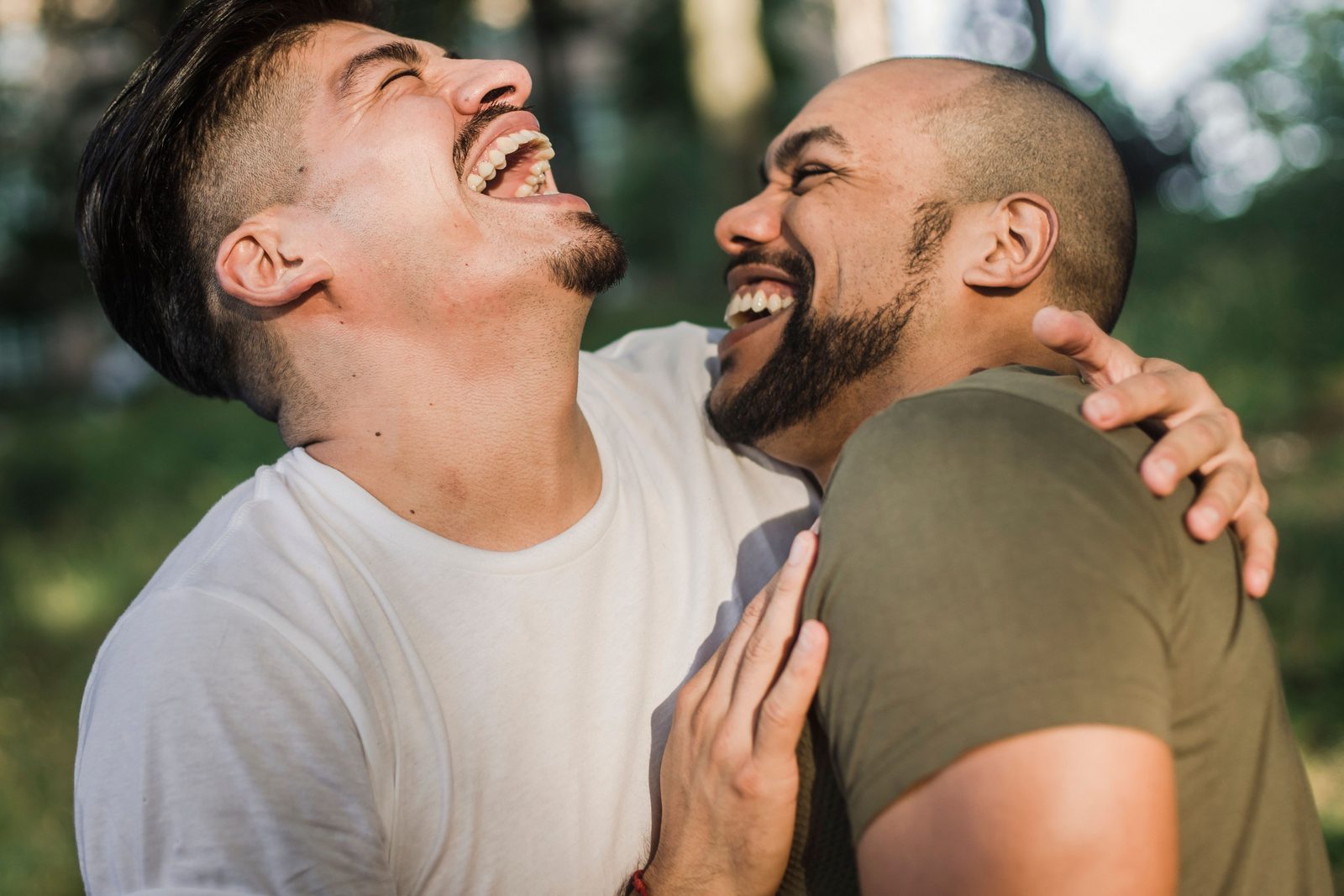 Two partners laughing together outdoors, enjoying a close and playful bond