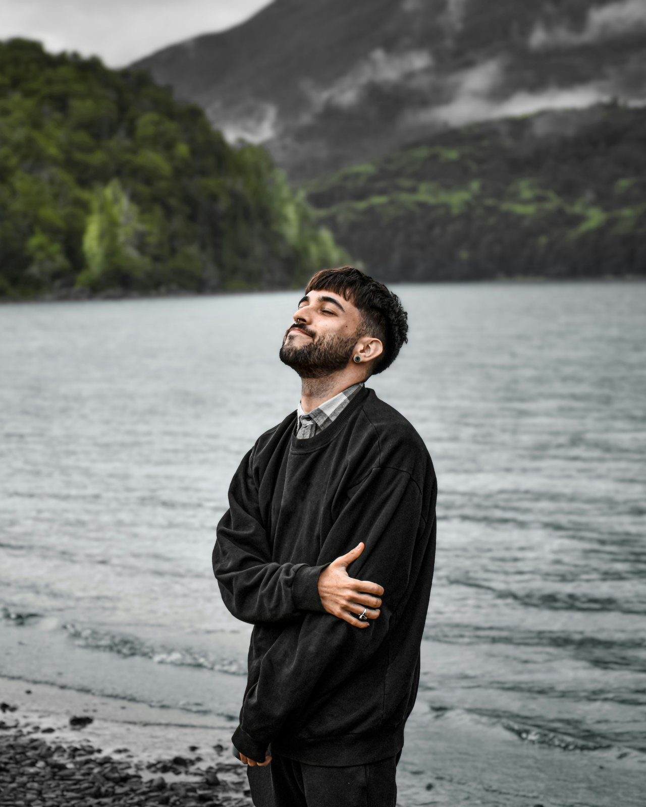 A person standing peacefully by the water, reflecting healing after trauma